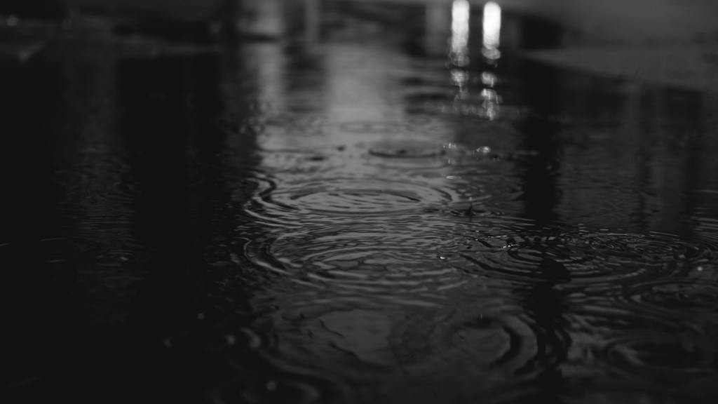 black and white photo of rain and puddles